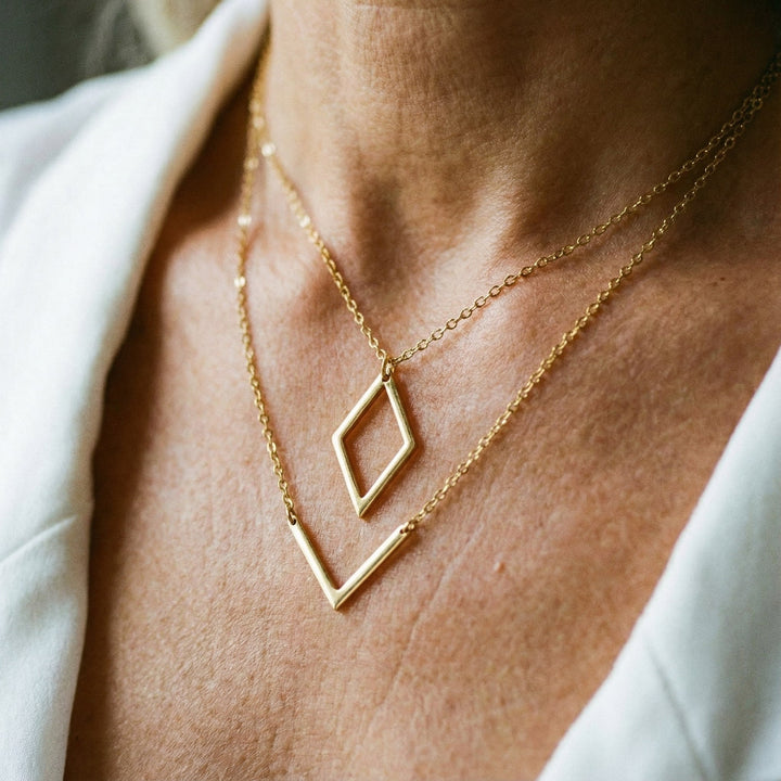 Elegants kaklarota ar ģeometrisku piekariņu V formā